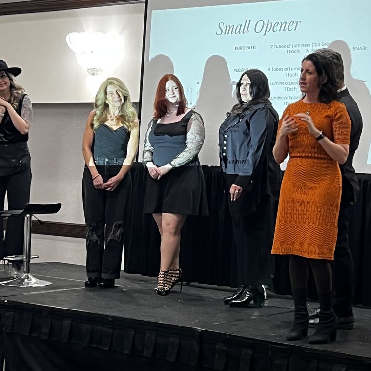 Jessica on stage with a team of stylists